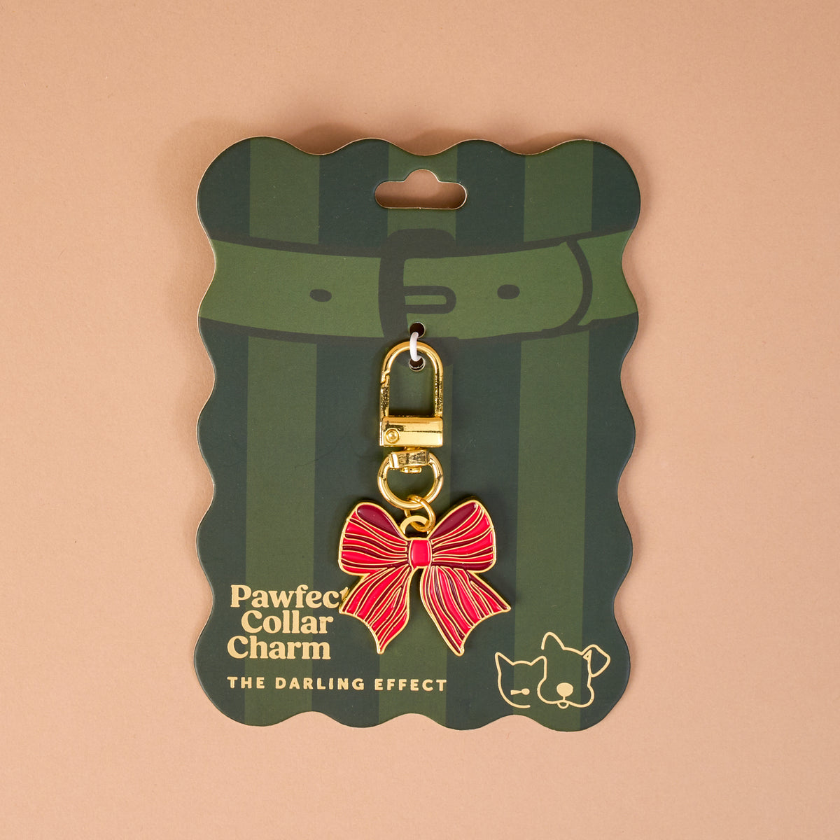 Holiday Bow Pawfect Collar Charm, a red and gold bow-shaped charm with a gold lobster clasp, attached to green striped display packaging for dog and cat collars.