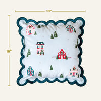 Home Sweet Home Scalloped Square Throw Pillow with a scalloped edge and an embroidered winter village scene featuring houses and evergreen trees.
