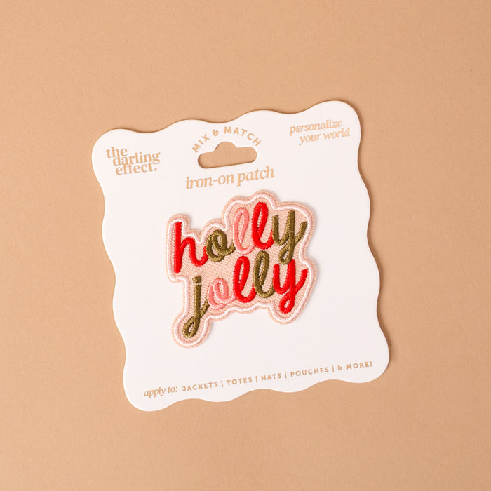 The Holly Jolly Mix & Match Iron-On Patch is an embroidered, colorful design displayed on a card, perfect for customizing your items.