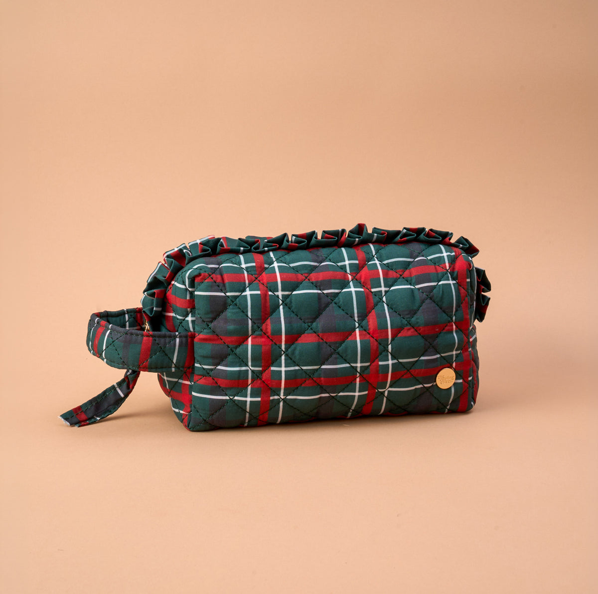 Evergreen Plaid Essentials Quilted Cosmetic Pouch in a green and red plaid pattern with a ruffled edge and a side carry strap.