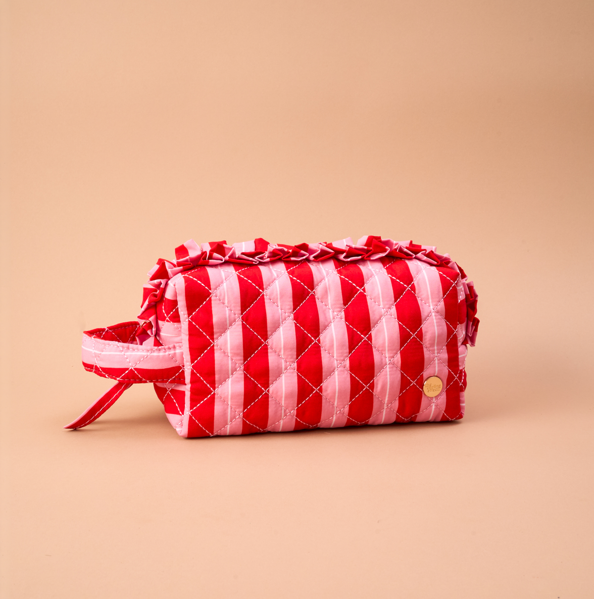 Peppermint Stripes Essentials Quilted Cosmetic Pouch featuring red and pink stripes and ruffled trim.
