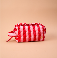 Peppermint Stripes Essentials Quilted Cosmetic Pouch featuring red and pink stripes and ruffled trim.