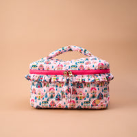 Sugarplum Lane Glam & Go Quilted Cosmetic Bag featuring a pink, light blue, and house pattern with a ruffled zipper trim and top handle, perfect as a travel makeup bag.