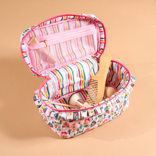 Open Sugarplum Lane Glam & Go Quilted Cosmetic Bag with a holiday house print, containing a makeup brush and a wooden comb.