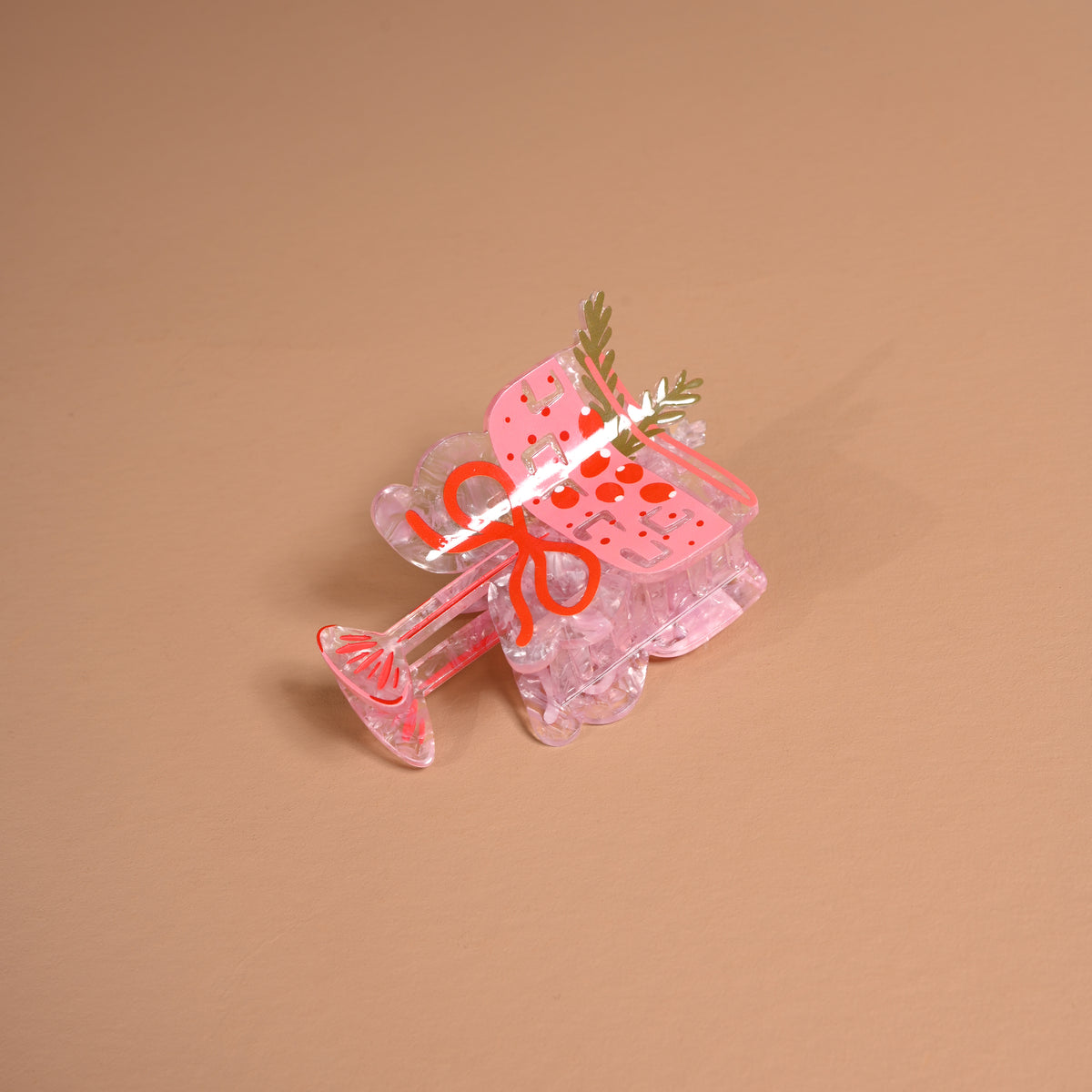 Clear pink Cranberry Cosmo Shape Up Claw Clip decorated with a cocktail glass and cranberry illustration, perfect for a cute hairstyle.