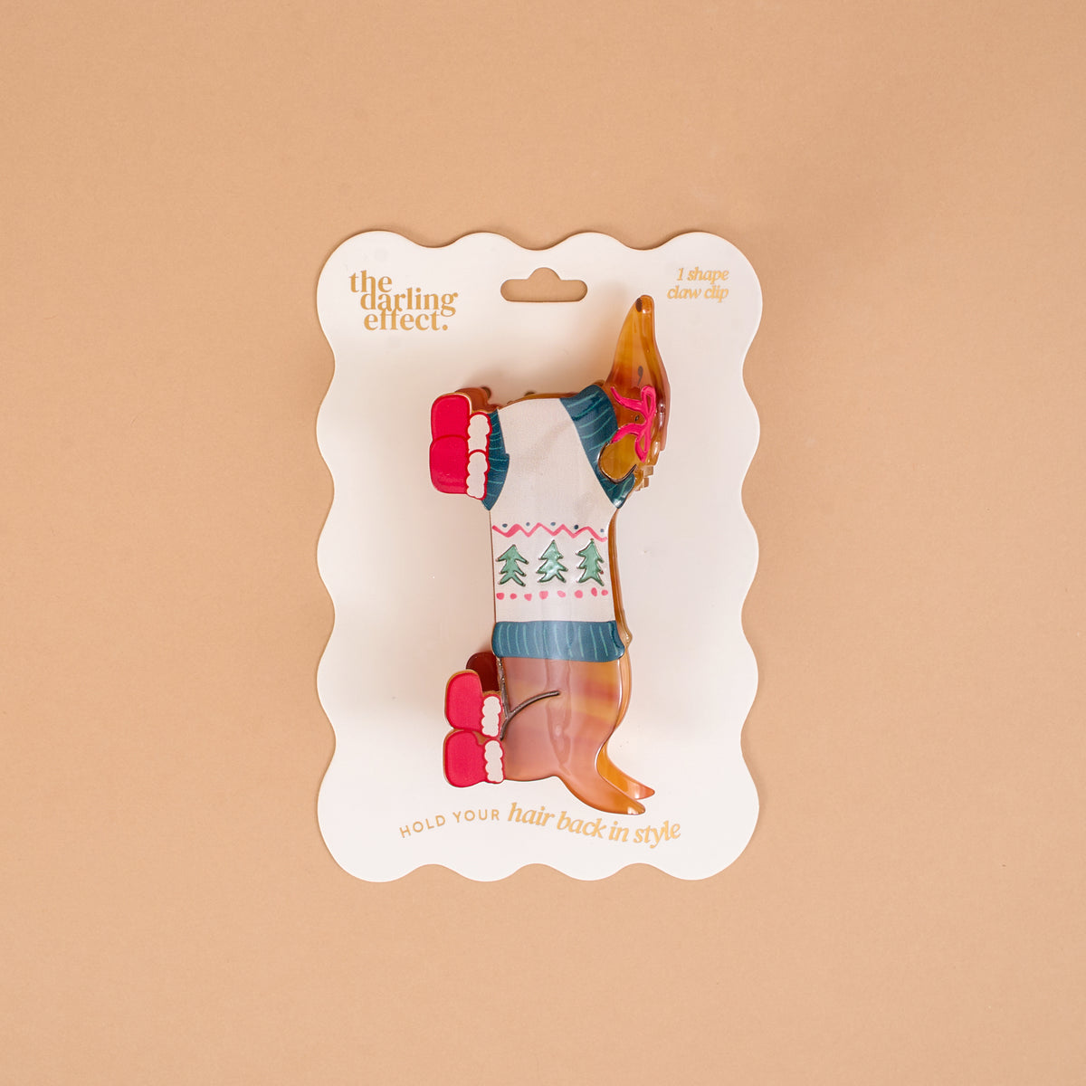 Dashing Dachshund Shape Up Claw Clip in the shape of a dachshund wearing a holiday sweater, packaged on a branded display card for a cute hairstyle.