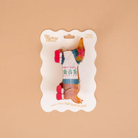 Dashing Dachshund Shape Up Claw Clip in the shape of a dachshund wearing a holiday sweater, packaged on a branded display card for a cute hairstyle.