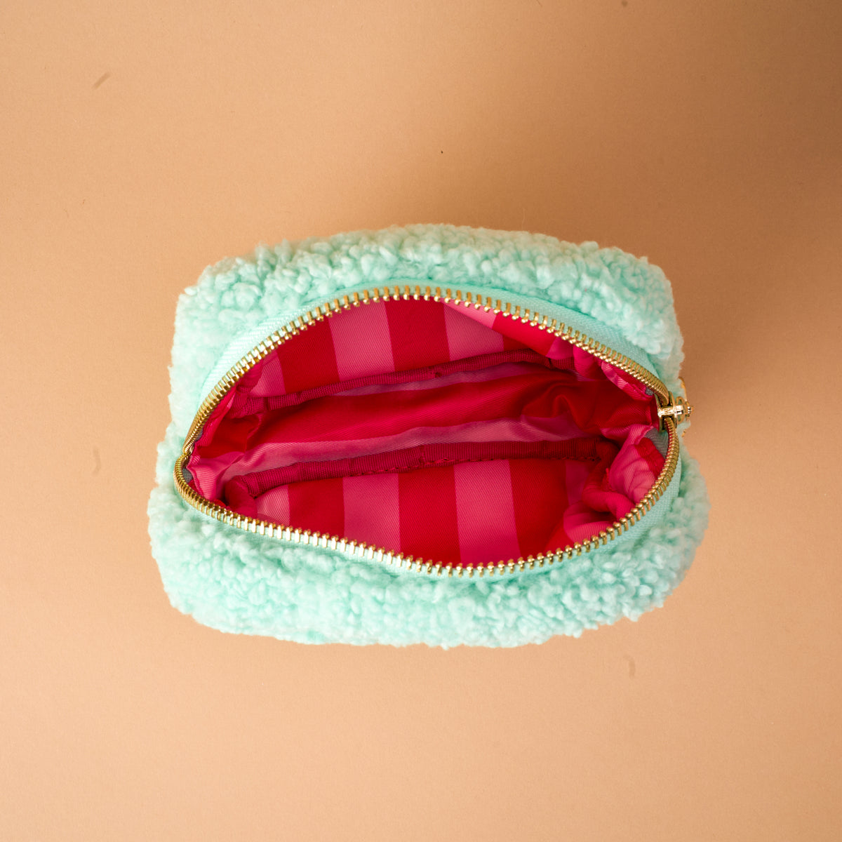Mint green sherpa Square Oh What Fun Teddy Pouch featuring a gold zipper and a pink-and-red striped interior lining.