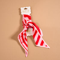 Peppermint Stripes Twirl & Tie Scarf Accessory in red and pink striped satin tied in a knot on a display card.