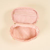 The-darling-effect Bouquet Beauty Sage Glam & Go Quilted Cosmetic Bag features an open, round pink floral design with a zipper, light pink interior with white flowers, a mesh pocket in the lid, and sits empty and flat on a cream background.