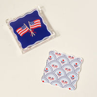 The Darling Effect’s All-American Darling Table Talk Acrylic Coaster Set features vibrant coasters adorned with crossed flags and patriotic florals—perfect table décor for any patriotic gathering.