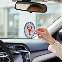 A person hangs The Darling Effect’s Lobster Sweet Ride Car Air Freshener from their rearview mirror, adding a long-lasting fragrance and bold red lobster style to their car.