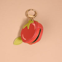 The Darling Effect Tomato Fruit Market Bag Charm is a small, round, red coin purse shaped like a tomato with a green leaf, gold keyring, and front zipper—perfect as a fruit bag charm or cute keychain. Set against a light beige background.