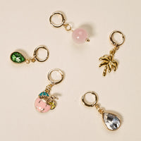 Five gold hoop earrings with charms—a green gem, pink bead, gold palm tree, pink cocktail, and clear teardrop gem—perfect for mixing and matching with The Darling Effect’s Island Time The Ultimate Charm Pack or statement necklaces.