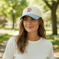 A woman with wavy brown hair, wearing a white t-shirt and The Darling Effect’s Star Spangled Bear Classic Canvas Hat, smiles softly while standing in a sunlit park.