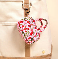 The Darling Effect's Strawberry Fields Itty Bitty Duffle Bag Charm is a small, quilted pink pouch with a red strawberry pattern, keyring attachment, short handle, and snap button closure—perfect as a cute bag accessory.