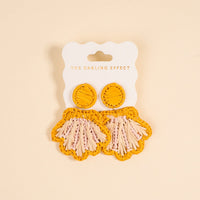 The Darling Effect’s Yellow Cabana Breeze Earrings feature yellow raffia shells with pink and cream fringe—lightweight, boho, and perfect for everyday wear.