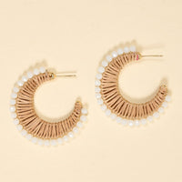 The Darling Effect’s Golden Sand It-Girl Earrings feature a crescent shape with beige woven thread and white beads on the edge—lightweight, perfect for daily wear, shown on a light beige background.