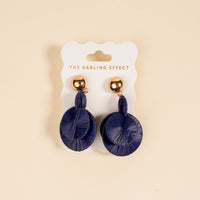 The Darling Effect's Navy Pretty and Polished Earrings—circular navy blue boho earrings with gold studs—are shown on a branded white card against a beige background, perfect for everyday style.
