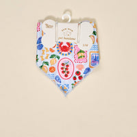 The Darling Effect Bow-Wow Pet Bandana-Ciao Bella (S/M) is a light blue cotton bandana for dogs with a vibrant Italian food-themed print, including crabs, tomatoes, pasta, lemons, and seafood. Displayed on a hanger with branded tag.