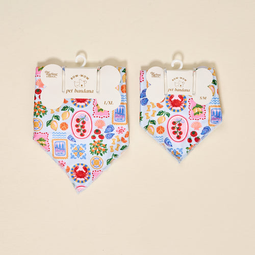 Two The Darling Effect Bow-Wow Pet Bandana-Ciao Bella accessories in L/XL and S/M, with a Mediterranean-inspired print of crabs, lemons, tomatoes, shells, and sardines on light blue—perfect for stylish pet fashion.