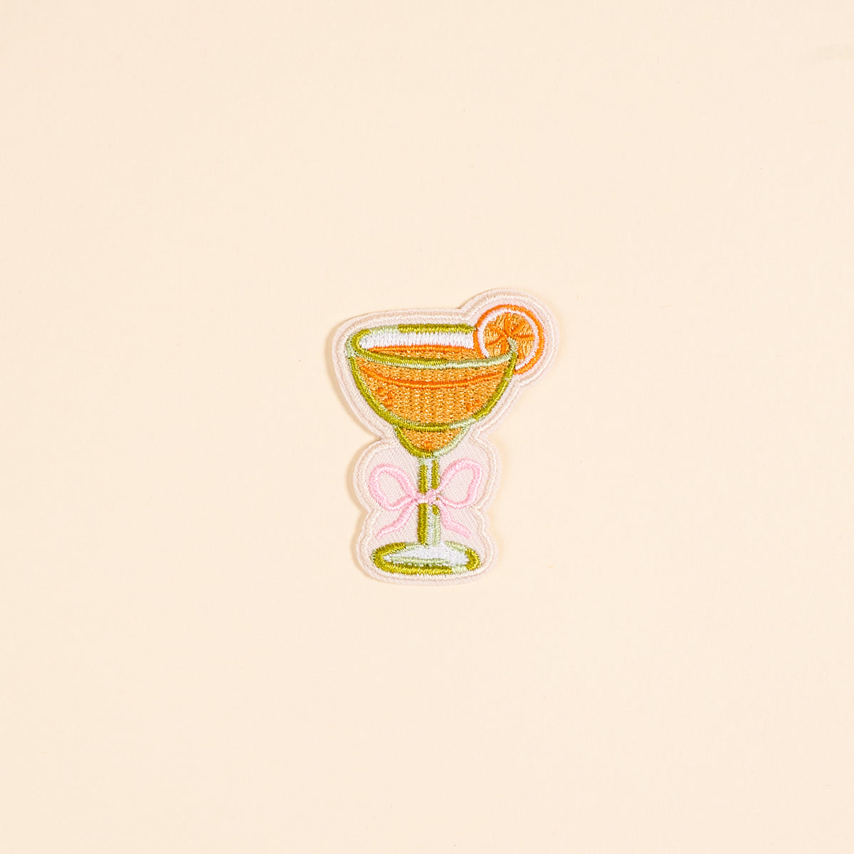 The Darling Effect Bow-Tied Margarita Mix & Match Iron-On Patch features a cocktail glass with an orange slice and pink bow—perfect for adding a pop of color and customizing your look.