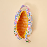 The Darling Effect’s Ciao Bella Essentials Quilted Cosmetic Pouch features a vibrant floral design, yellow zipper, orange striped lining, and a pale yellow backdrop—ideal as a travel pouch for all your makeup essentials.