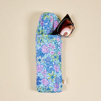 The-darling-effect’s Coastal Cove Sunglasses Case features a blue, pink, and green quilted pattern with a magnetic flap; tortoiseshell sunglasses peek out for a touch of style and extra protection.