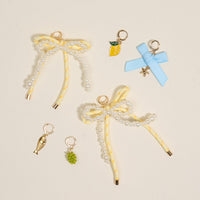 Add a splash of summer to your sneakers with The Darling Effect’s Summer Soirée Dazzle Shoe Charm Pack—featuring pearl-beaded yellow bows, a lemon, blue starfish bow, golden fish, and green grapes for irresistible charm.
