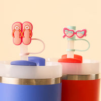 The Sunny Style Straw Topper Set by the-darling-effect includes two vibrant tumblers (blue and red) with straws and fun silicone toppers—pink flip-flops and heart sunglasses—for playful, functional drinkware.