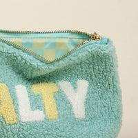 The Salty Teddy Pouch by the-darling-effect features a teal sherpa exterior, pastel checkered lining, and "SALTY" in white and yellow chenille letters—a standout, on-trend bag for any collection.