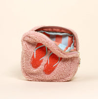 The Darling Effect's Square Flip Flops Teddy Pouch features fluffy pink sherpa, embroidered orange flip-flops, a striped lining, and cozy teddy vibes.