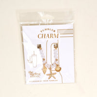 The-darling-effect Under the Sea Tumbler Charm set features gold seashell, leaf, and starfish charms with white beads. Packaged on a backing card in clear wrap labeled "Tumbler Charm," these are perfect tumbler or drinkware accessories.