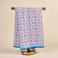 The All-American Darling Waffle Tea Towel by The Darling Effect features red, blue, and light blue floral and geometric designs with a blue border, making it a stylish and functional accent for any kitchen.