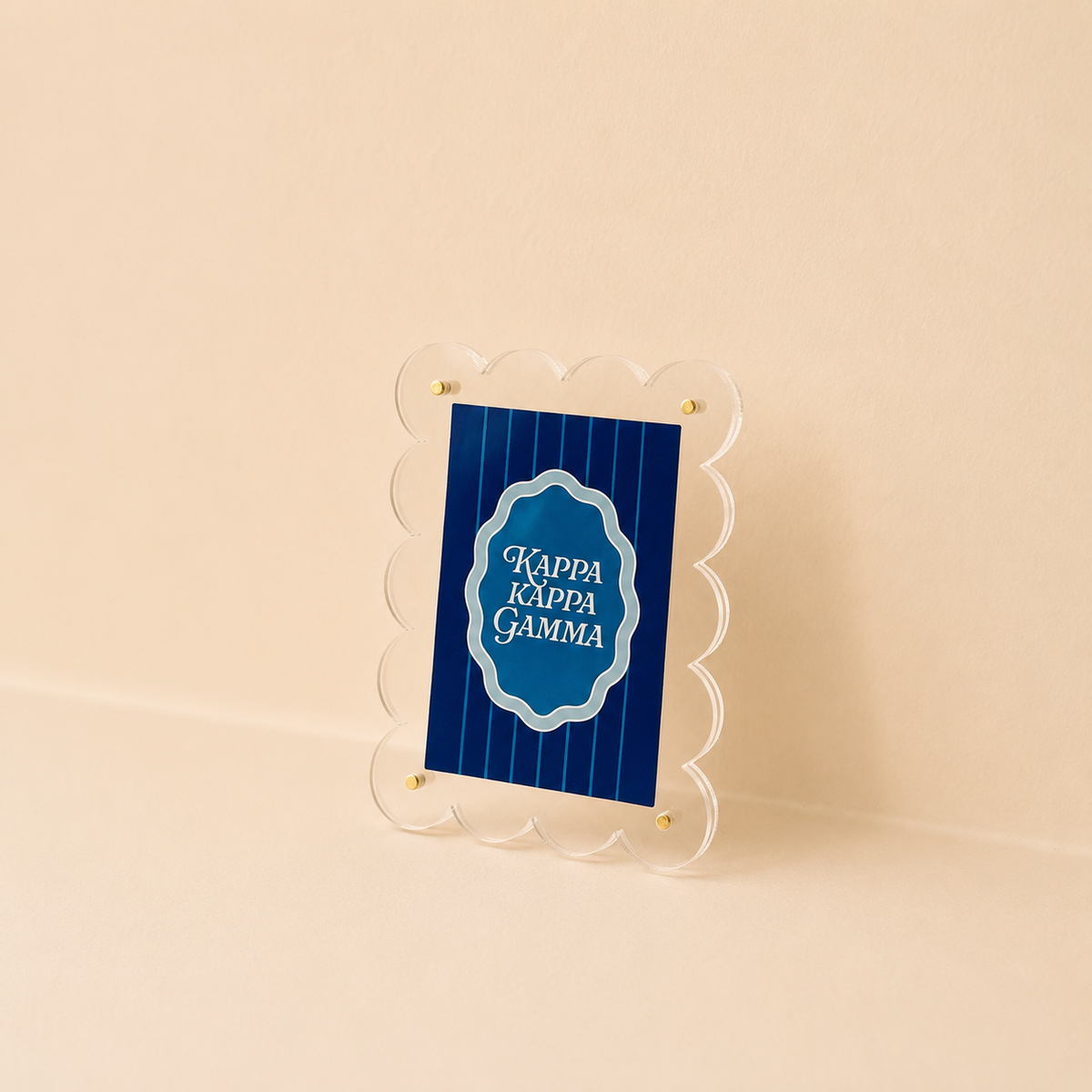 The Darling Effect Kappa Kappa Gamma Mini Acrylic Picture Frame Magnet features a scalloped-edge clear frame holding a blue sign with white text, displayed on a beige background.
