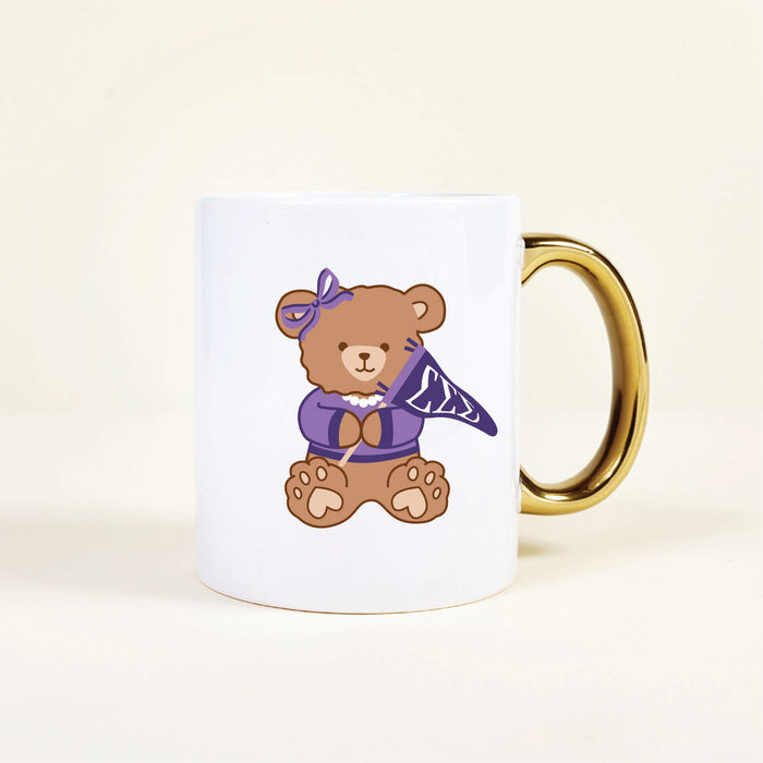 The Darling Effect’s Sigma Sigma Sigma 11 oz Cozy Cute Ceramic Mug features a ceramic teddy bear with a gold handle, purple bow, pearl necklace, and patterned scarf—perfect for any sorority mug collection.