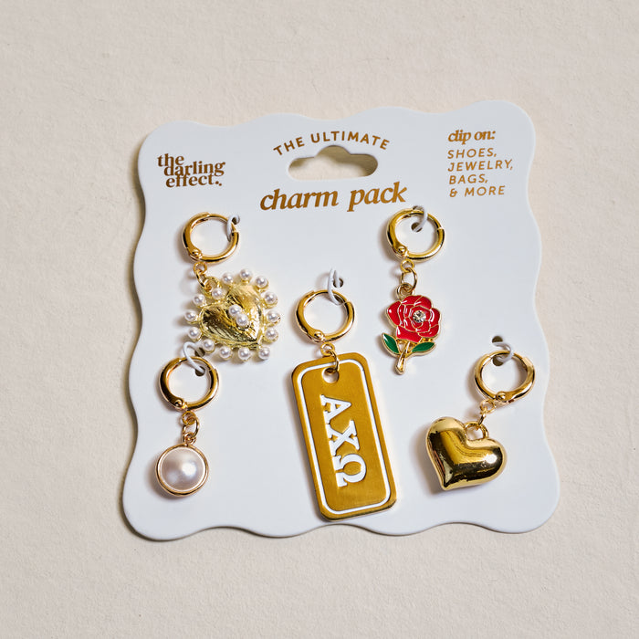 Show off your sorority spirit with The Darling Effect's Alpha Chi Omega The Ultimate Charm Pack—five gold charms on a display card, featuring a pearl, two hearts, a red rose, and an ΑΧΩ tag.