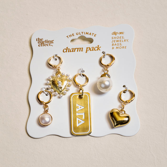 The Darling Effect’s Alpha Gamma Delta The Ultimate Charm Pack features five gold charms—a heart, pearl, beaded heart, round pearl, and a geometric tag—perfect for shoes, jewelry, bags, or showing off sorority style.