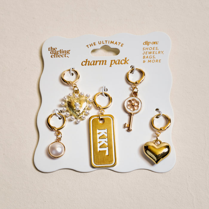 The Darling Effect's Kappa Kappa Gamma The Ultimate Charm Pack includes five gold charms—a pearl, jeweled heart, sorority tag, key, and gold heart—on a white card. Perfect for shoes, jewelry, or making unique charm necklaces.