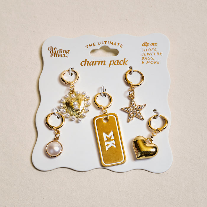 The Darling Effect's Sigma Kappa The Ultimate Charm Pack features five gold charms—a pearl, ornate heart with pearls, Greek letter tag, rhinestone star, and shiny heart—on a display card for the ultimate Sigma Kappa style.