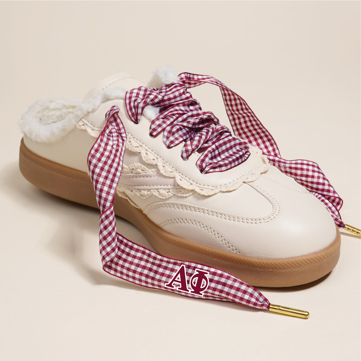 Alpha Phi Step It Up Shoelaces by The Darling Effect feature a maroon-and-white gingham print, gold tips, and Greek letters Alpha Phi—stylish sorority gifts perfect for any sneaker upgrade.