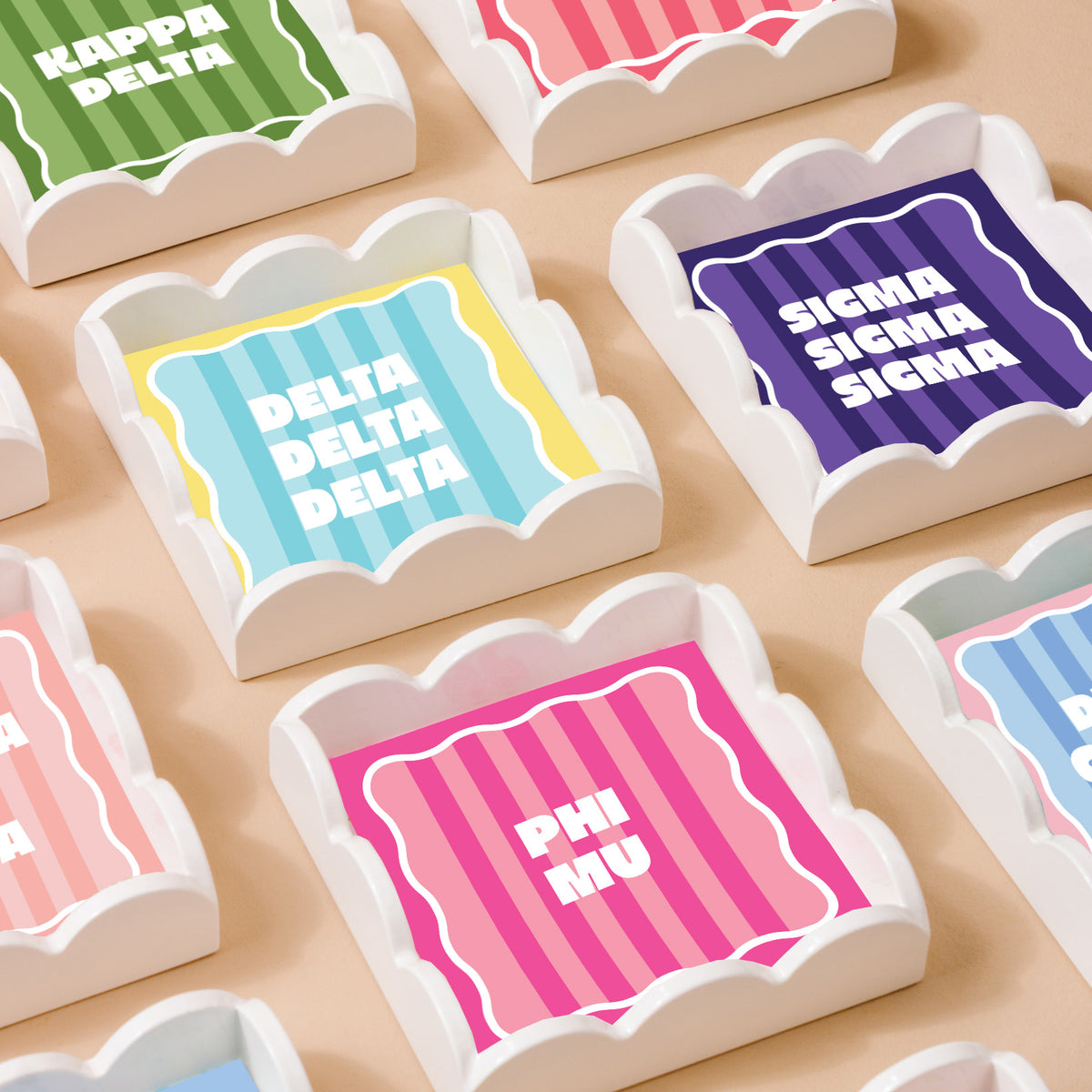 The Darling Effect’s Sigma Kappa Scallop Trinket Tray features wavy edges and bold white Greek letters on a striped background—perfect as a jewelry organizer or accessory tray.
