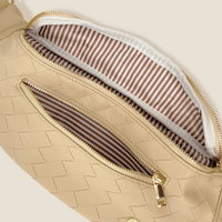 The Darling Effect's Woven Oat Trendy Luxe Belt Bag features beige woven fabric, gold zippers, a brown and white striped lining, a spacious main compartment, and a front pocket—ideal for adding style to any outfit.