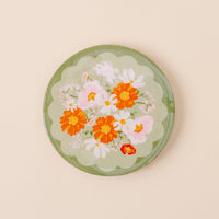 Display your Bouquet Beauty Sage Wood Enamel Coasters by the-darling-effect on this round green tray with a scalloped edge and a charming floral design—an elegant way to showcase stylish or decorative drink coasters.