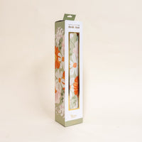 A rectangular box with a clear window displays the-darling-effect's Bouquet Beauty Sage Style Station Desk Mat, featuring a floral pattern in white, orange, and green against a plain light background. The mat is non-slip.