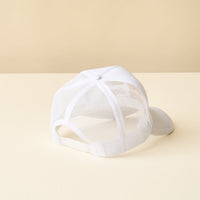 The Sunny Daze Trucker Hat by the-darling-effect is displayed back-facing on a light cream surface with a beige background—ideal for fans of trendy hats.