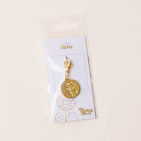 April Jewelry Birth Flower Charm Gold by the-darling-effect—an elegant, meaningful accessory, presented on a card that reads "April Daisy," perfect for fans of personalized jewelry.