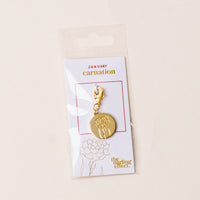 The-darling-effect's January Jewelry Birth Flower Charm Gold features a carnation design on a card labeled "January Carnation." Packaged in a clear sleeve, it's an ideal keepsake for personalized jewelry lovers.