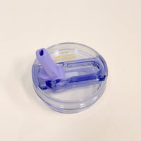 The Darling Effect's 20 oz Periwinkle Lifestyle Flip Straw Replacement Lid features a round, transparent design with a purple flip-up straw and gold "NEW! leak-resistant flip straw lid" text, shown on a white background.
