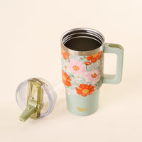 The-darling-effect's Bouquet Beauty Sage 20 oz Lifestyle Flip Straw Tumbler, featuring a floral pattern and handle, is filled with a dark drink. Its clear, leak-resistant lid with straw rests beside it on a light surface.